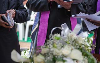 3 african american priests reading scriptures at a funeral near los angeles