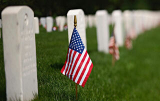 flag in front of gravestone at riverside national cemetery